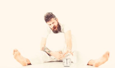 Pijama ve saati açmak için deneyin oturan adam