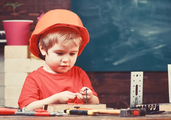 어린 시절 개념입니다. 소년은 작성기 또는 자 플레이, 도구를 사용. 어린이 건축 또는 건물에서 미래의 직업에 대 한 꿈. 주황색 모자 또는 헬멧, 연구 방 배경에서 소년 아이 — 스톡 사진