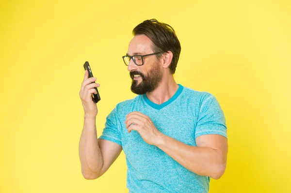 Hipster cheerful use smartphone. Man happy user of modern smartphone. Stay in touch with modern smartphone. Join online community. User friendly concept. Man excited about mobile phone opportunities