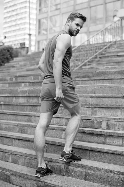 Man in motion on stairs looks back urban background. Every step brings him closer to success. Sportsman workout on stairs. Future success concept. Ready overcome any obstacle. Man making step higher