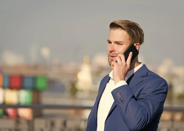 Manager with beard on smiling face hold phone