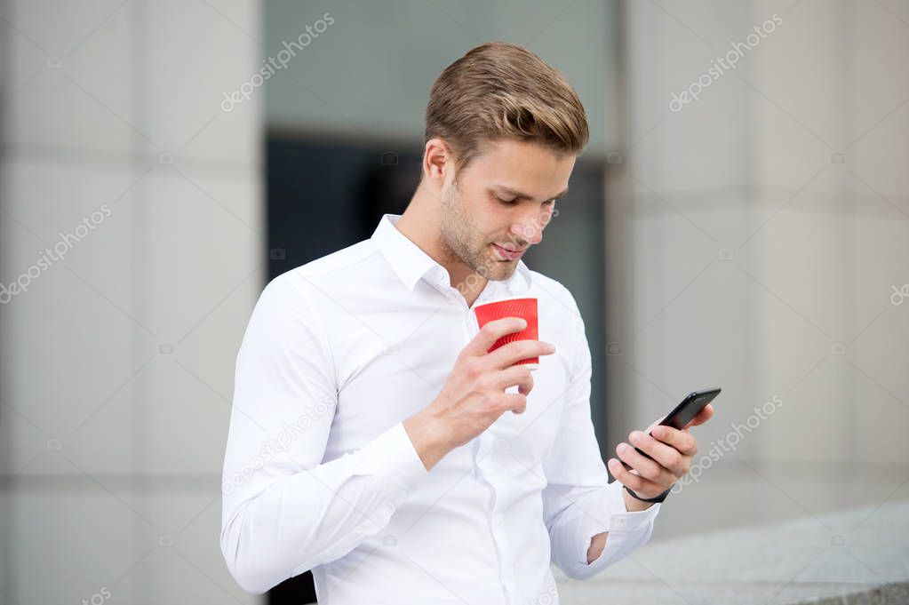 Send message. Man drinks coffee read message urban background. Start great day. Businessman relaxing with coffee morning time. Guy handsome attractive businessman need energy charge. Incoming message