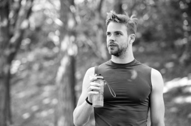 Dinlenmek için bir dakika. Adam atletik görünüm şişe su ile tutar. Adam atlet spor giysileri hakkında su dengesi umursamıyor. Spor ve sağlıklı yaşam tarzı. Sporcu içmek su Park eğitimden sonra