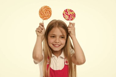 Girdap karamel ile gülümseyen kız. Küçük çocuk gülümseme ile şeker beyaz izole sopa üzerinde. Tatlı ve son derece büyük. Lolipop gülümseyerek mutlu bir çocuk. Yemek ve tatlı. Beslenme ve diyet