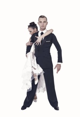 Dans eden balo çifti beyaz sahilde yalnız poz veriyor.