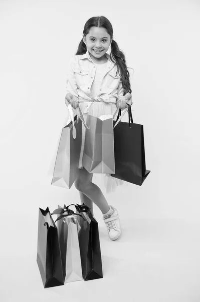Pakket en meisje. meisje met kleurrijk pakket. boodschappenpakket in de hand van een meisje. Meisje met pakkettas. kleine winkelverslaafde. — Stockfoto