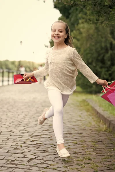 Söt liten flicka promenader med rosa shoppingväskor — Stockfoto