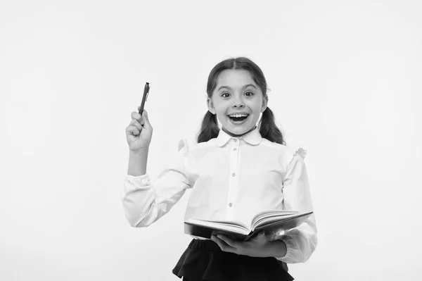 Dziewczyna cute uczennica w mundurze trzymać książkę lub podręcznik żółty tło. Staranny uczeń zdobywa wiedzę z książki. Dziecko nosi szkolny mundur przygotować się do lekcji jej wiedzy. Podekscytowany wiedzą — Zdjęcie stockowe