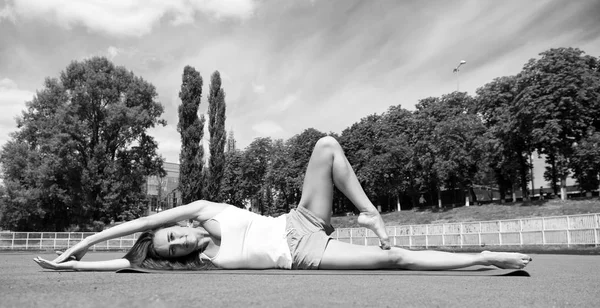 Yoga helps find harmony. Woman flexible body practice yoga lay fitness mat outdoors nature background. Girl stretching body workout. Stretching muscles every time training. Coach tips and advice — Stock Photo, Image