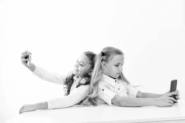 Dependencia del teléfono móvil y selfie. los niños pequeños hacen selfie en el teléfono en la escuela aislado en blanco, espacio de copia. vida de los estudiantes con dependencia del teléfono móvil — Foto de Stock