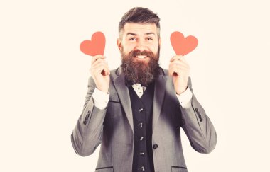 Beyaz arka plan üzerinde izole kırmızı kalpler holding neşeli acımasız adam