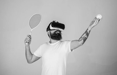 Sanal gerçeklik kulaklık tenis oynuyor, yakışıklı adam arka plan gri. Yenilikçi spor oyunları için modern teknolojisini kullanıyor. Vr gözlüklü play tenis raket ve top ile. Sanal Tenis kavramı