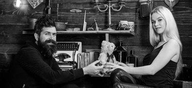 Adam Bayan oyuncak ayı için yıldönümü hediye olarak vermek. Gülümseyen yüzler üzerinde aşık çift tatilin keyfini çıkarın. Çift gamekeepers evde, ahşap iç arka plan romantik akşamın. Yıldönümü kavramı