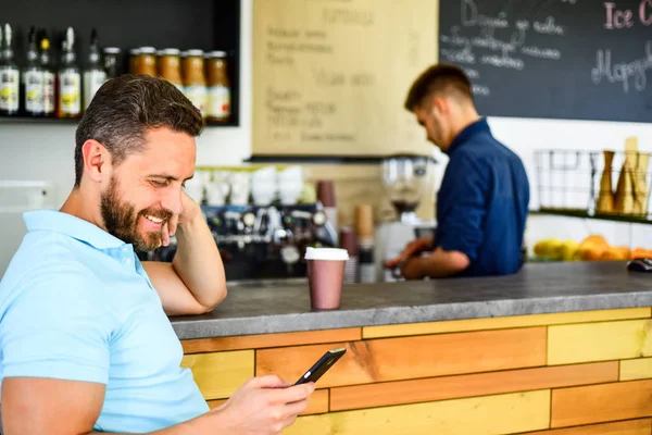 モバイル メッセージ カフェ バリスタの背景を読む男。待っている間にコーヒーを飲みます。メッセージを確認してください。男のスマート フォン注文のカフェでコーヒー。コーヒー ブレークのコンセプトです。コーヒーを奪う忙しい人のためのオプション — ストック写真