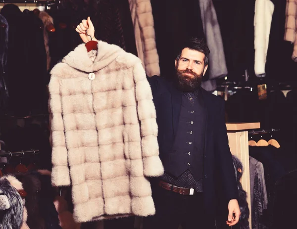 Man met baard en snor houdt vacht. Winter kleding concept. — Stockfoto