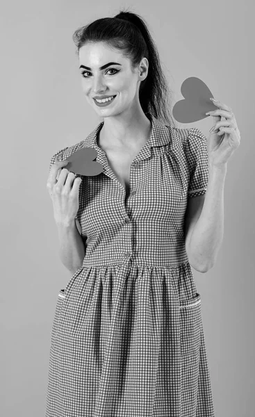 Muchacha atractiva sosteniendo dos corazones rojos en sus manos, aislados sobre fondo rosa. Amor, feliz, concepto de San Valentín — Foto de Stock