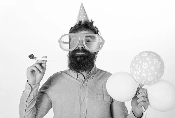 Party concept. Hipster in gigantische zonnebril viert verjaardag. Guy in feest hoed met partij hoorn viert. Man met baard en snor op blij gezicht houdt lucht ballonnen, witte achtergrond — Stockfoto