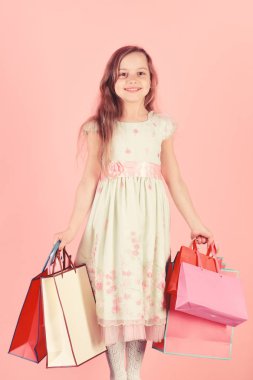 Mutlu yüz kızla alışveriş torbaları, pembe arka plan tutar.
