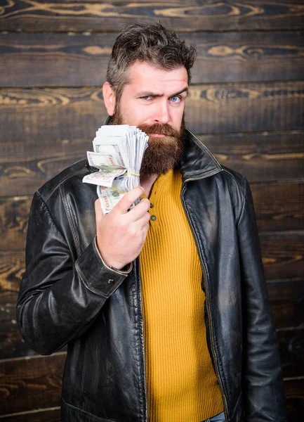 Brutal man has cash money. Richness and wellbeing. Man brutal bearded hipster wear leather jacket and hold cash money. Mafia business. Illegal profit and black cash. Guy mafia dealer with cash profit
