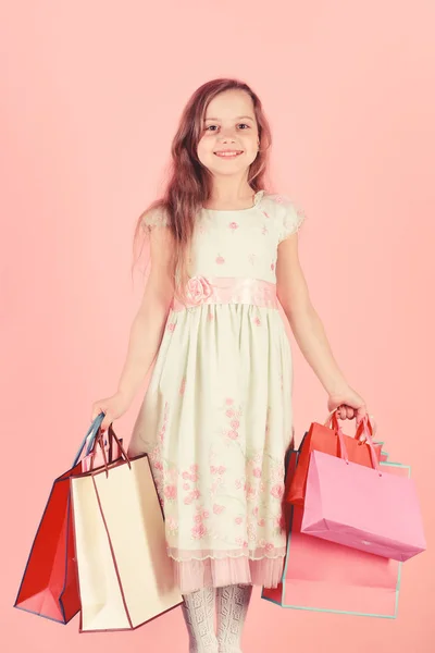 Boldog arcú lány tart bevásárló táskák, rózsaszín háttér — Stock Fotó