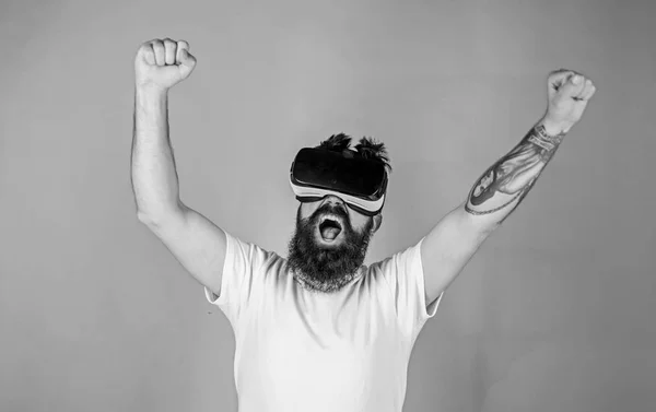 Homme à barbe dans des verres VR, fond vert. Hipster en criant visage levant les mains puissamment tout en interagissant dans la réalité virtuelle. Le gars avec écran monté sur la tête interagit en VR. Concept de puissance — Photo