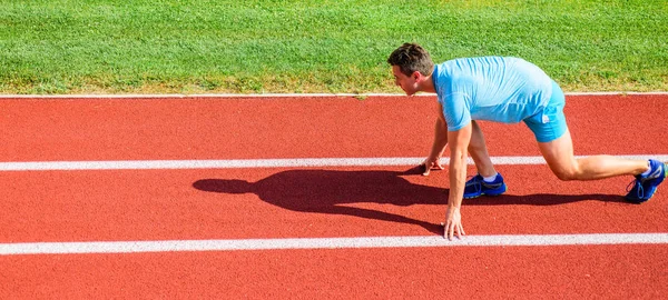 Spor motivasyon kavramı. Adam atlet runner standı düşük başlangıç pozisyonu stadyum yolu güneşli bir gün. Runner gitmeye hazır. Zafer için çaba. Yetişkin runner yarış Stadyumu'nda hazırlayın. Yayınlanmaya başlaması nasıl
