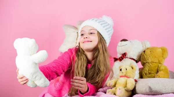 Criança menina pequena brincalhão segurar ursinho brinquedo de pelúcia. Ursos de pelúcia ajudam as crianças a lidar com emoções e limitar o estresse. Kid menina brincar com urso de pelúcia de brinquedo macio no fundo rosa. Ursos brinquedos coleção — Fotografia de Stock