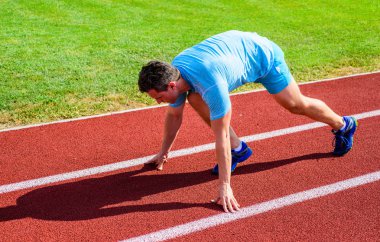 Runner gitmeye hazır. Yetişkin runner yarış Stadyumu'nda hazırlayın. Nasıl yayınlanmaya başlaması. Profesyonel atlet spor ipuçları. Adam atlet runner standı düşük başlangıç pozisyonu stadyum yolu. Zafer için çaba