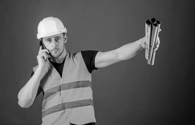 Adam inşaat telefon, kırmızı zemin üzerine denetlemektedir. Mühendis, mimar meşgul yüzündeki telefonla konuşuyor, planları tutan, parmakla işaret ederek, alan Kopyala. Tedarik malzemeleri kavram oluşturma