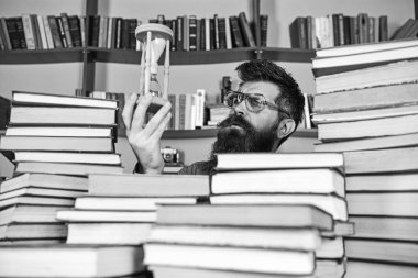 Adam düşünceli yüzünde ise eğitim, kitap rafı arka plan üzerinde kum saati tutar. Dostum, bilim adamı bardaklarda kum saati görünüyor. Öğretmen ya da sakal Kitaplığı'nda eğitim ile öğrenci. Zaman akışı kavramı