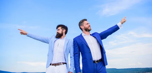 Changing course. Men formal suit managers pointing at opposite directions. New business directions. Developing business direction. Businessmen bearded faces stand back to back sky background
