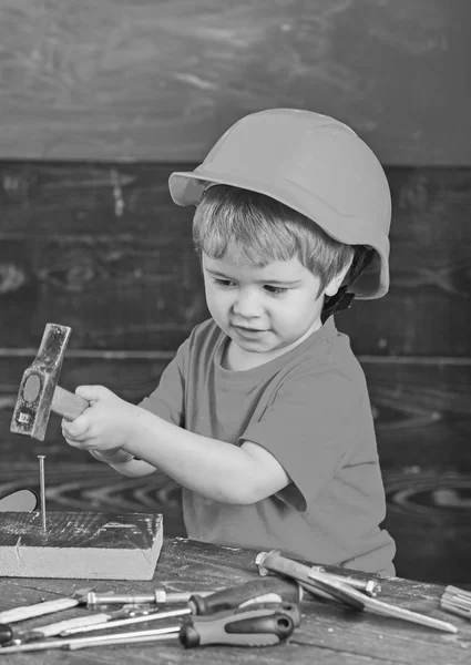 직장에서 안전입니다. 손톱 망치 주황색 헬멧에 작은 꼬마. 도구를가지고 노는 귀여운 소년 — 스톡 사진