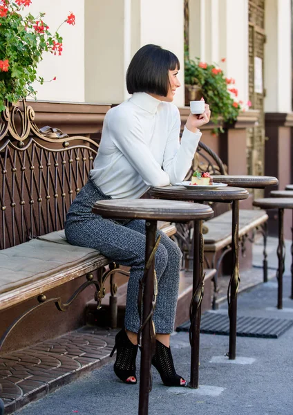 Gurmánský koncept. Žena atraktivní elegantní bruneta vychutnat gurmánskou kávu café terasy pozadí. Příjemný čas a relaxaci. Delicious a gurmánské pití. Dívka relax kavárna káva a dezert — Stock fotografie