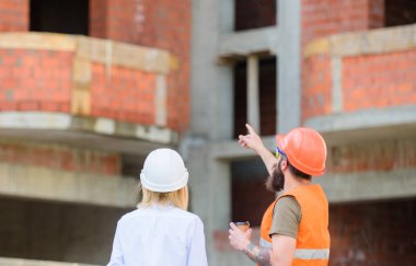 İnşaat ekibi iletişim kavramı. Planı tartışıyor. Kadın mühendis ve Oluşturucu inşaat alanında iletişim. İnşaat istemcileri ve inşaat sektöründe katılımcılar arasındaki ilişkileri