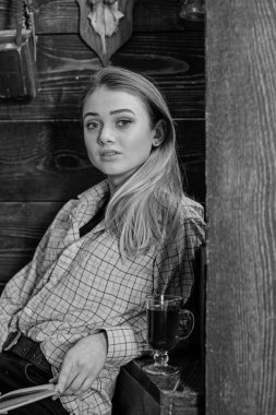 Bayan kareli giysiler içinde rüya gibi yüzünde rahat görünüyor. Gündelik kıyafeti kız ahşap vintage iç oturur. Gevşeme kavramı. Kız öğrenci mulled şarap, kadeh ile rahatlatıcı yakın çekim