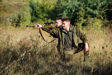 Hobby for real men concept. Hunters with rifles in nature environment. Hunter friend enjoy leisure in field. Hunters gamekeepers looking for animal or bird. Hunting with friends hobby leisure clipart