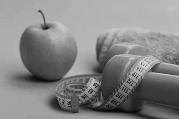 Dumbbells in bright green color, measure tape, towel and fruit — Stock Photo, Image