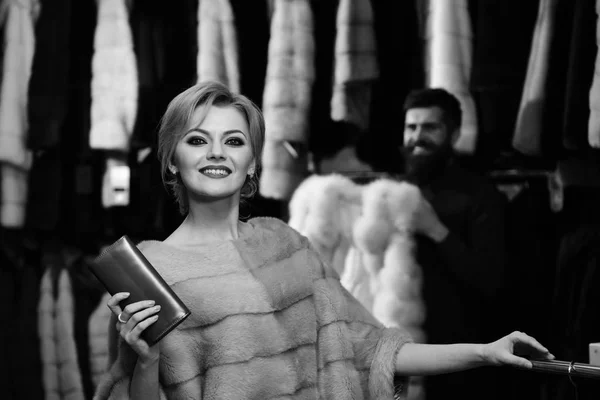 Assistente de loja com barba e mulher escolher casaco peludo — Fotografia de Stock