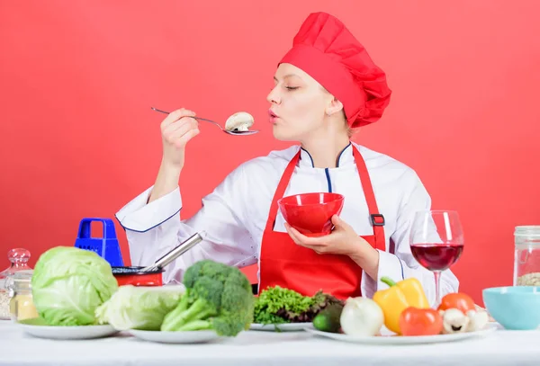 Eet gezond. Gezonde rantsoen. Professionele chef-kok vrouw houd lepel met rauwe paddestoel. Gezonde vegetarische en veganistische recepten. Gezonde rauwkost. Dieet concept. Meisje slijtage hoed en schort proberen paddestoel smaak — Stockfoto