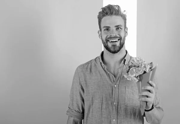 Elle sera mienne. L'homme prêt à sortir apportera des fleurs roses. Petit ami confiant tient bouquet attendant la date. Le mec apporte un cadeau romantique agréable qui l'attend. Macho tient bouquet comme cadeau romantique — Photo