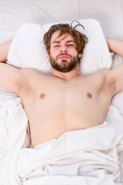Όμορφος άνδρας χρησιμοποιώντας το ρολόι στο κρεβάτι μετά το ξύπνημα το πρωί. Τεντώστε μετά την ενεργοποίηση μέχρι το πρωί. Ξυπνάτε ενέργειας. — Φωτογραφία Αρχείου