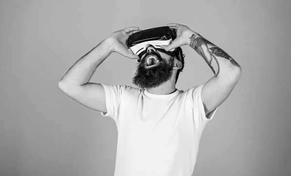 Homem com barba hipster desfrutando de novidade tecnológica digital. Homem barbudo excitado assistindo filme em óculos VR, conceito de experiência 3D. Artista com barba na moda e tatuagem verificando a visualização de seu trabalho — Fotografia de Stock