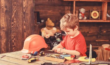 Çocuk Çocuk tamirci oynamak. Çocukluk kavramı. Çocuk şirin ve sevimli araçlarla builder veya repairer oynarken, onarma veya handcrafting. Evde araçlarında atölye ile yürümeye başlayan çocuk meşgul yüz üzerinde çalış