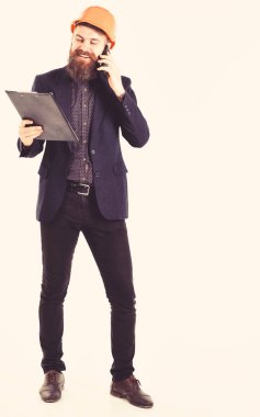 Gülümse, başarı, yeni teknolojiler, geliştirme, duygular kavramı. İşadamı yapı planı ve telefon görüşmeleri tutar. Mutlu bir adam kask takıyor. Kağıtları ve neşeli yüz tutan smartphone ile mühendis