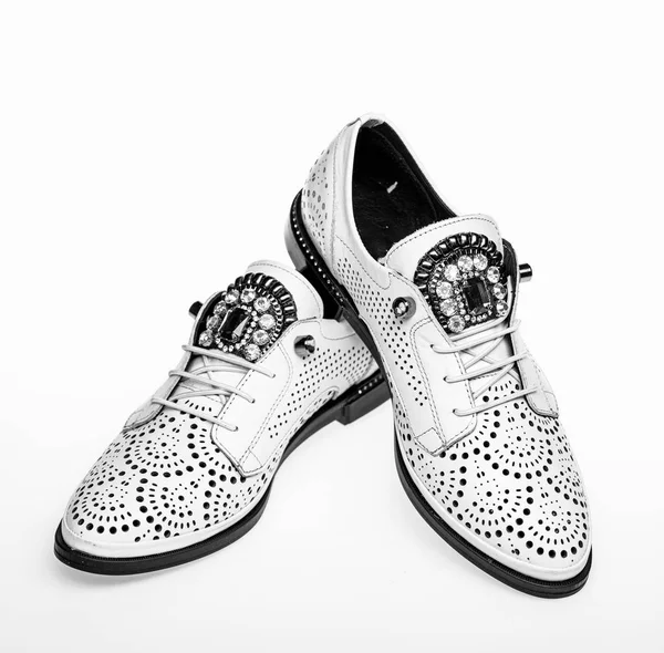 Pair of fashionable comfortable oxfords shoes. Female footwear concept. Footwear for women on flat sole with perforation and rhinestones. Shoes made out of white leather on white background, isolated — Stock Photo, Image