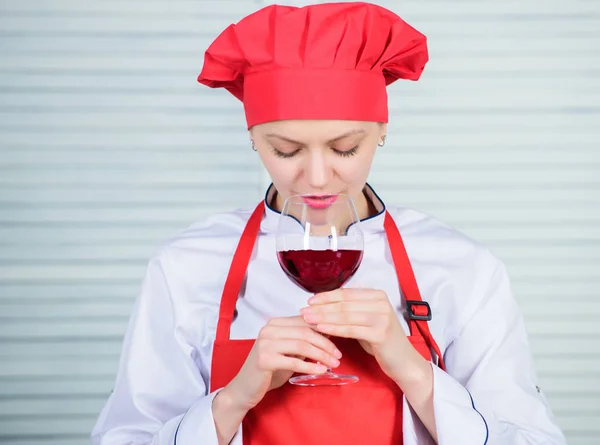 Exquisite dinner concept. Wine degustation. Which wine to serve with dinner. How to match wine and food like expert. Girl wear hat and apron enjoy aroma of drink. Woman chef hold glass of wine