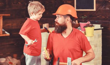 Evlat, çocuk neşeli anahtar anahtarı, baba ile öğrenme kullanım araçları tutar. Baba, üst koruyucu kask okul atölyesinde farklı araçları kullanmak için küçük oğlu öğretim içinde sakallı. Babalık kavramı