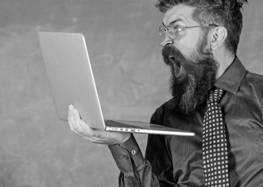 Şok edici bilgi. Yenilikçi öğretmen giyim gözlük kravat laptop internet'te sörf sahiptir. Öğretmen modern dizüstü sörf internet kara tahta arka plan ile şok adam sakallı. Şok haber