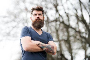 Kuaför kavramı. Bıyık ciddi bir yüz emin doğa arka plan ile sakallı adam. Gözlüklü sakallı adam. Hipster emin tutun çarpı işareti kollar göğüs üzerinde sakallı. Sakallı hippi acımasız Maço