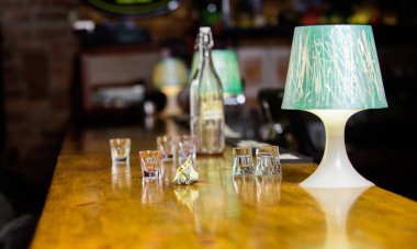 İçki sipariş çubuk. Satın alma ve ödeme. Nakit para kavramı. Barmen için ipuçları bırakın. Garsona verilen ipucu. Buruşuk para nakit bar sayacı. Boş bardak ve şişe üzerinde tablo. Nakit ödeme